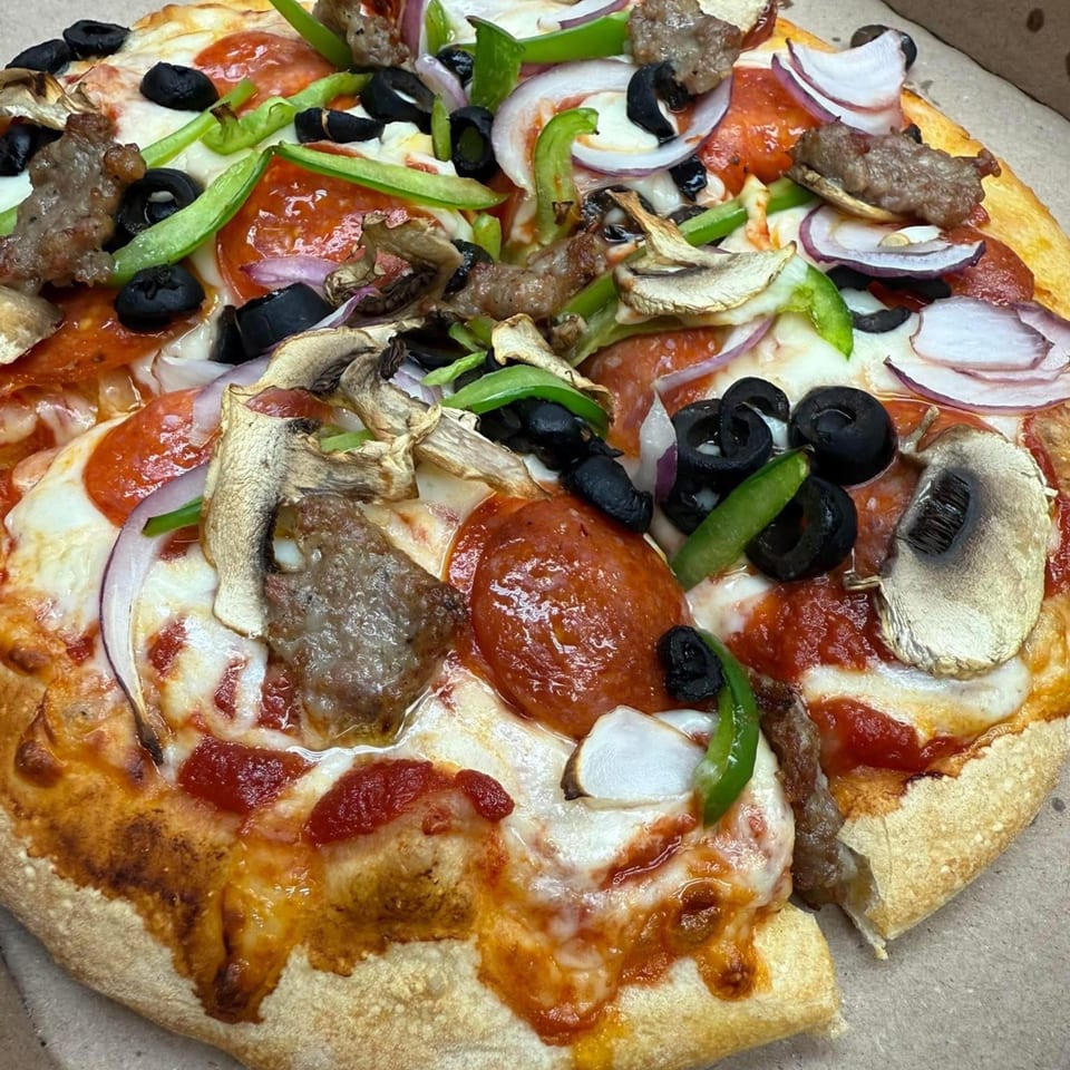 Rego's Brickhouse Pizza with pepperoni, sausage, mushrooms, olives, green peppers, and red onions.